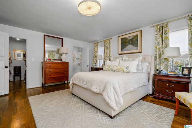 bedroom featuring multiple windows, wood finished floors, and ensuite bathroom