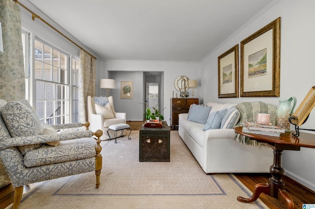 living area with crown molding, baseboards, and wood finished floors