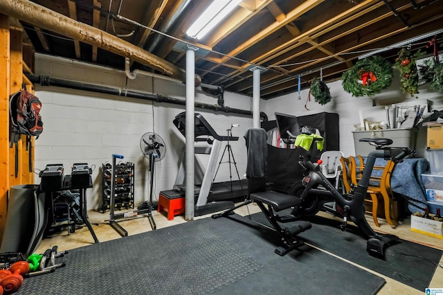 exercise room featuring concrete block wall