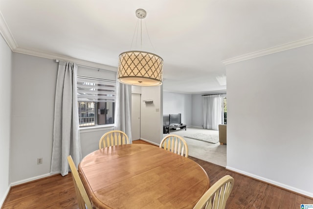 dining room with crown molding, baseboards, and wood finished floors