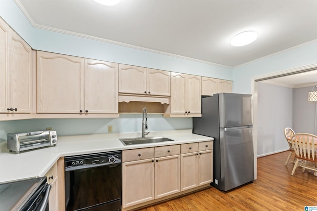 kitchen featuring light brown cabinets, crown molding, black dishwasher, freestanding refrigerator, and a sink