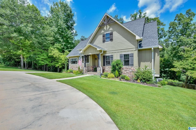 craftsman inspired home featuring stone siding, roof with shingles, board and batten siding, and a front lawn