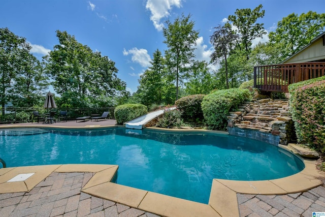 view of pool with a fenced in pool, a patio, a water slide, and fence