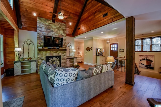 living room featuring visible vents, a fireplace, wood ceiling, wood-type flooring, and ceiling fan with notable chandelier