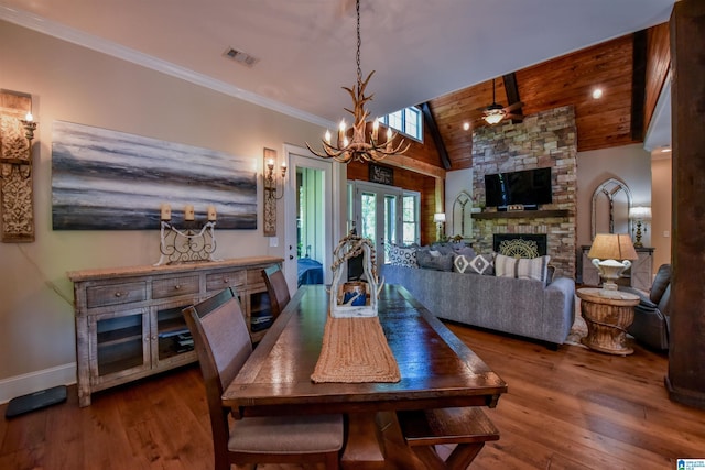 dining area with visible vents, ornamental molding, a fireplace, wooden ceiling, and wood finished floors