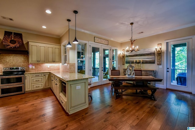 kitchen with visible vents, custom range hood, cream cabinetry, french doors, and appliances with stainless steel finishes