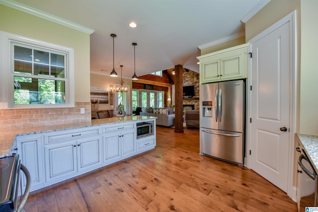 kitchen featuring light wood-type flooring, ornamental molding, tasteful backsplash, open floor plan, and appliances with stainless steel finishes