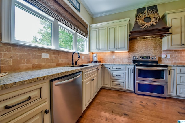 kitchen featuring backsplash, appliances with stainless steel finishes, crown molding, and custom range hood