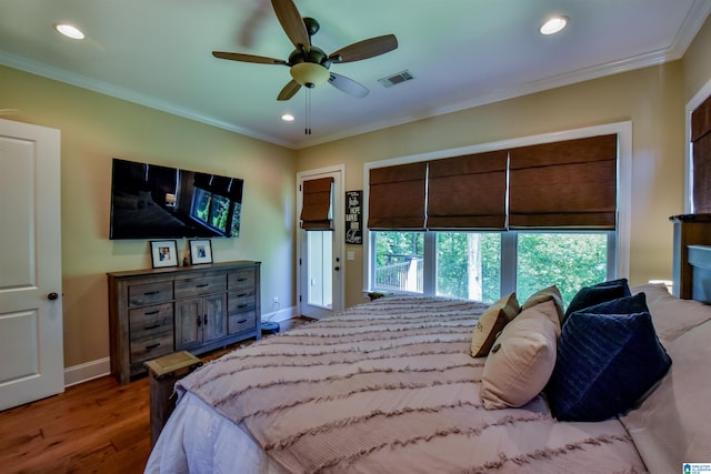 bedroom featuring visible vents, wood finished floors, baseboards, and ornamental molding