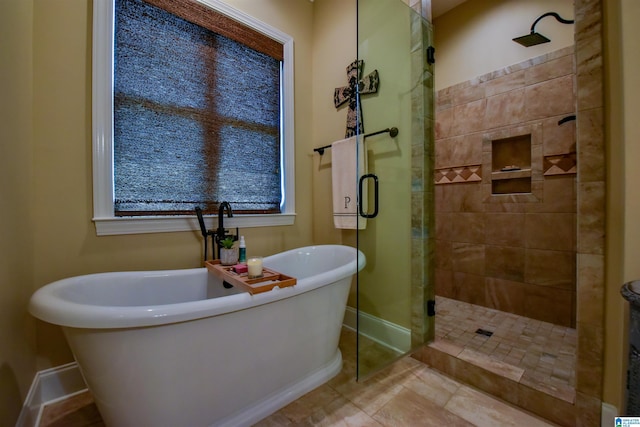 bathroom featuring a freestanding tub, baseboards, and a stall shower