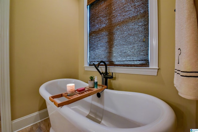 bathroom with a freestanding bath and baseboards