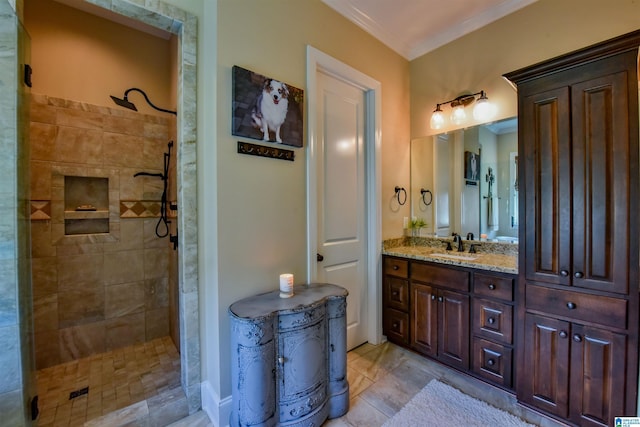 full bath with ornamental molding, vanity, and a tile shower