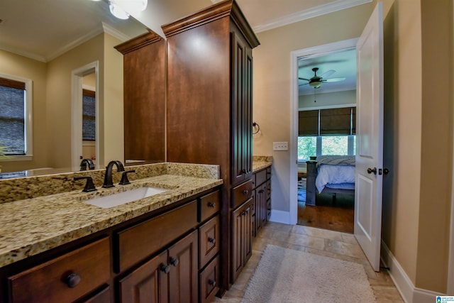 bathroom with vanity, crown molding, baseboards, and ensuite bath