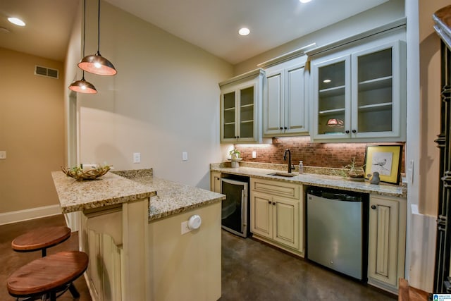 kitchen with wine cooler, a breakfast bar area, a peninsula, cream cabinetry, and fridge