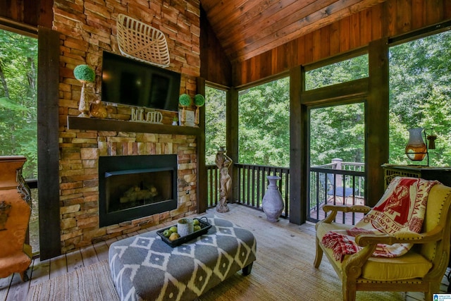 sunroom / solarium featuring lofted ceiling and a fireplace