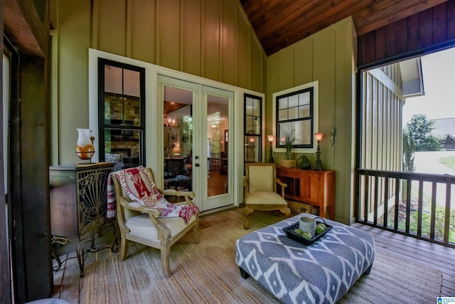 sunroom / solarium featuring a stone fireplace, lofted ceiling, wood ceiling, and french doors