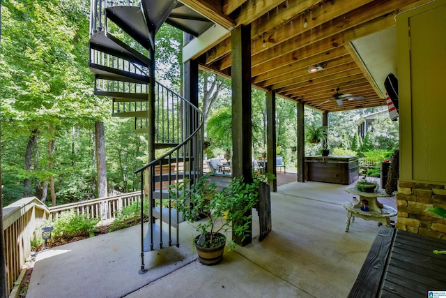 view of patio / terrace with stairway, ceiling fan, and a hot tub