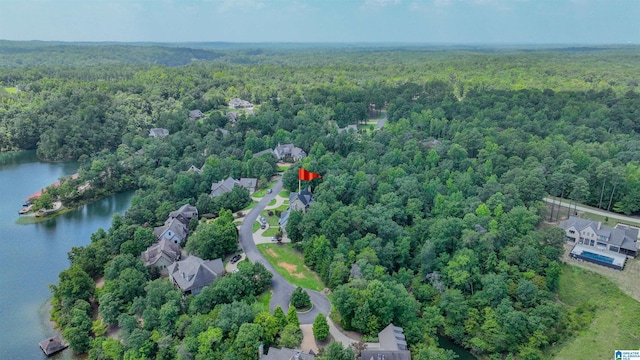 drone / aerial view featuring a wooded view and a water view