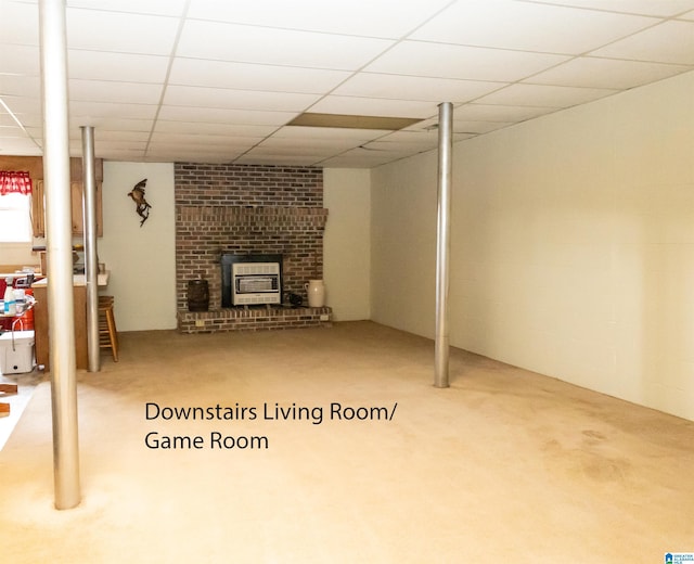 basement with heating unit, a drop ceiling, and carpet