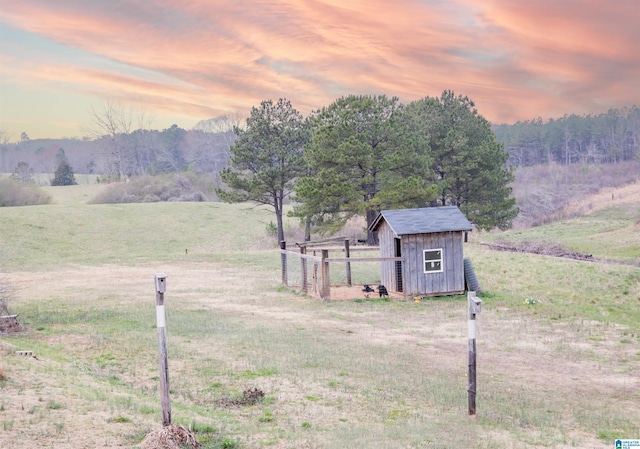 yard at dusk with an outbuilding and a rural view