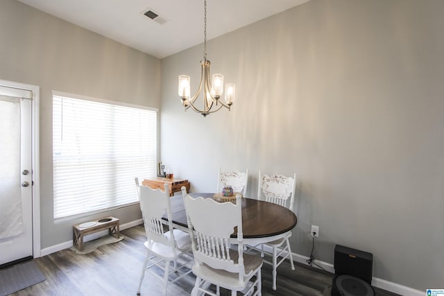 dining room featuring visible vents, baseboards, an inviting chandelier, and wood finished floors