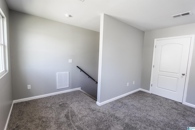 carpeted spare room with baseboards and visible vents