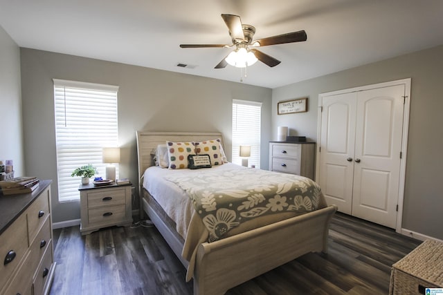 bedroom featuring a closet, baseboards, visible vents, and dark wood-style floors