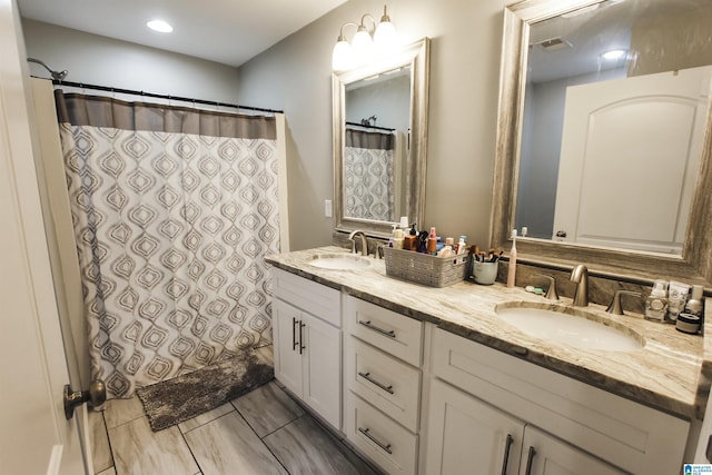 full bath with a sink, visible vents, curtained shower, and double vanity