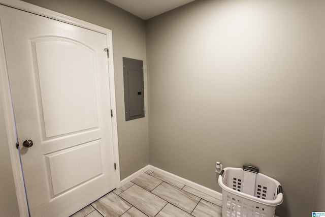 laundry room with electric panel and baseboards