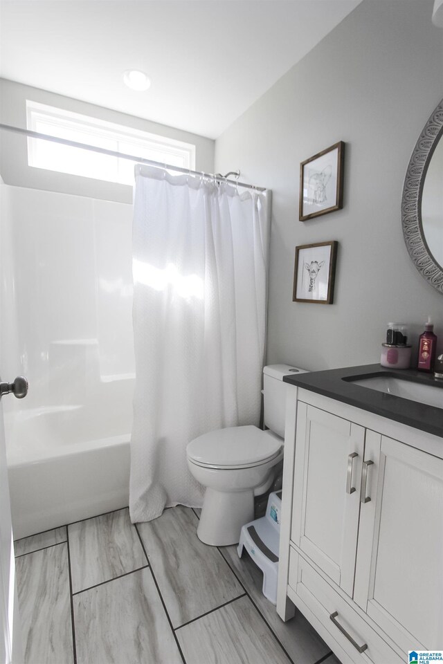 bathroom featuring shower / bath combination with curtain, toilet, and vanity