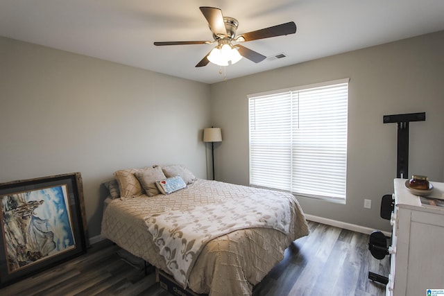 bedroom featuring visible vents, baseboards, a ceiling fan, and dark wood-style flooring