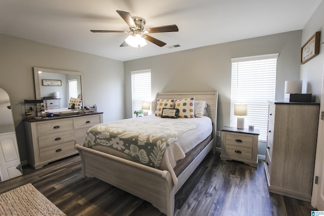 bedroom with a ceiling fan, dark wood-style floors, and visible vents