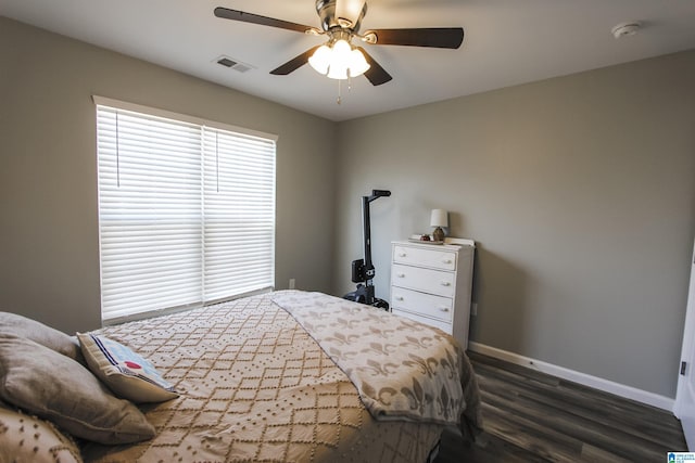 bedroom with visible vents, baseboards, a ceiling fan, and dark wood-style flooring