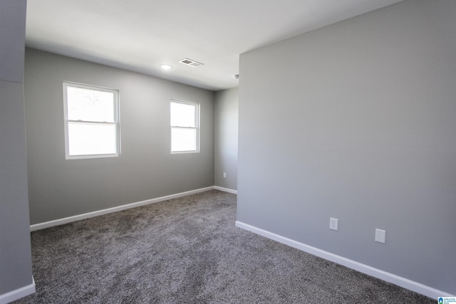 empty room featuring carpet flooring, baseboards, and visible vents