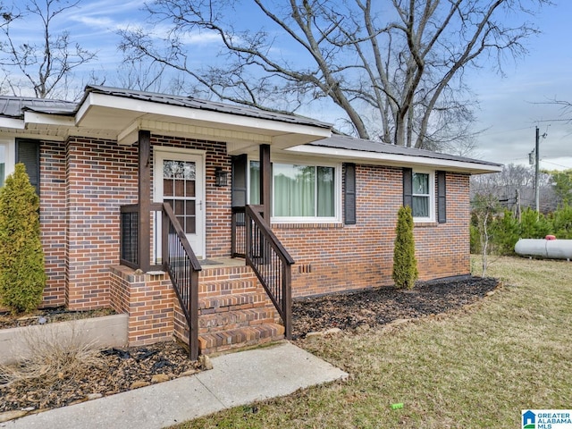 view of front of property featuring brick siding, crawl space, and metal roof