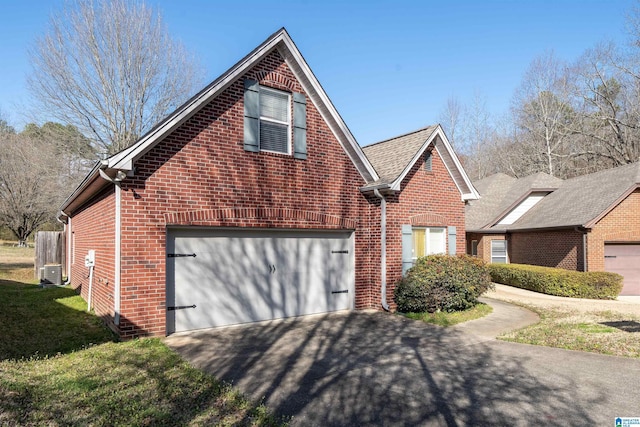 view of front facade with aphalt driveway, a garage, brick siding, and a front yard