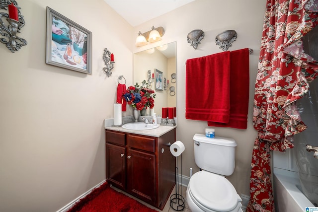 bathroom featuring baseboards, toilet, and vanity