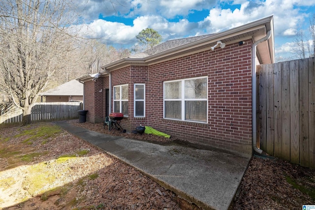 view of property exterior with brick siding and a fenced backyard