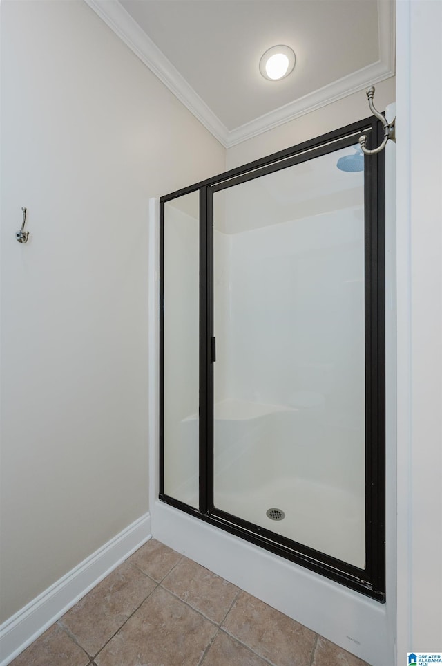 full bath with a stall shower, baseboards, crown molding, and tile patterned floors