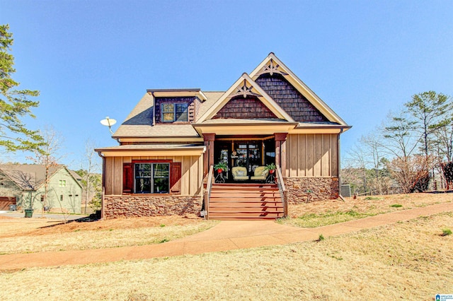 craftsman house featuring stone siding and board and batten siding