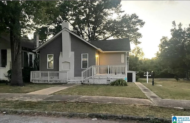 bungalow with a chimney and a front lawn