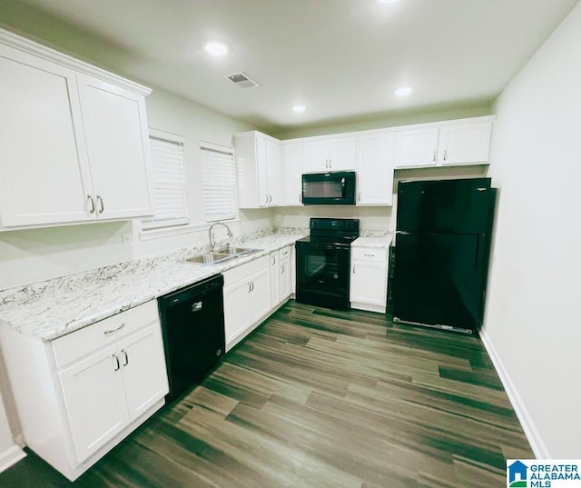 kitchen with black appliances, white cabinets, visible vents, and a sink