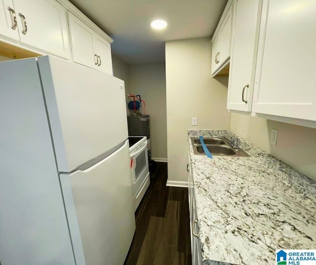 kitchen featuring white cabinetry, white appliances, dark wood-type flooring, and a sink