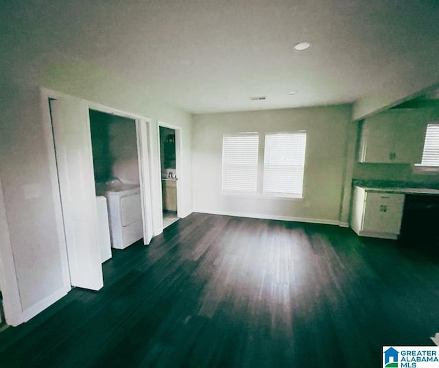 unfurnished living room featuring dark wood finished floors, baseboards, and independent washer and dryer