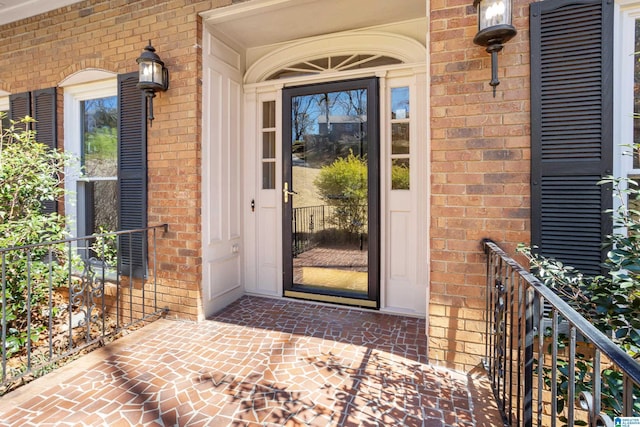 view of exterior entry featuring brick siding