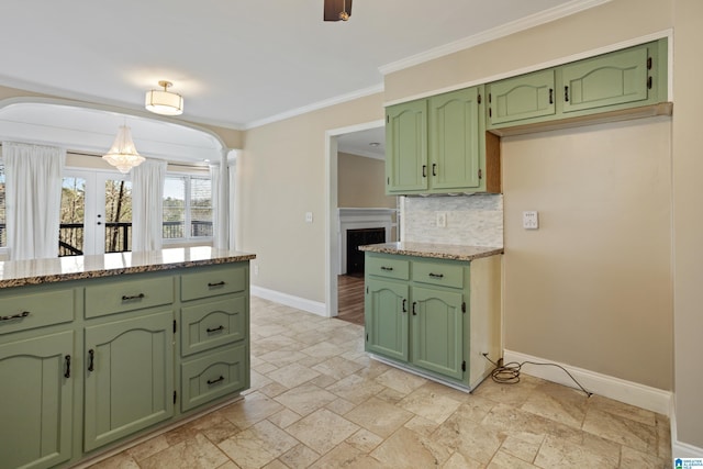 kitchen with arched walkways, backsplash, and green cabinets