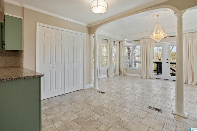 interior space with visible vents, arched walkways, crown molding, decorative columns, and baseboards