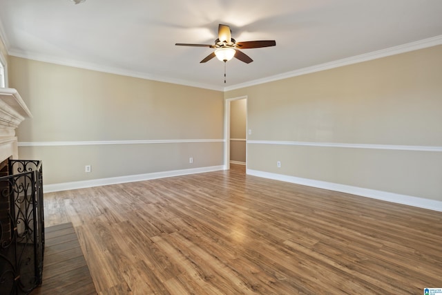 unfurnished living room with ornamental molding, wood finished floors, baseboards, and ceiling fan