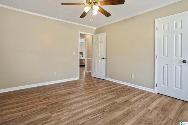 unfurnished bedroom featuring a ceiling fan, wood finished floors, baseboards, and ornamental molding