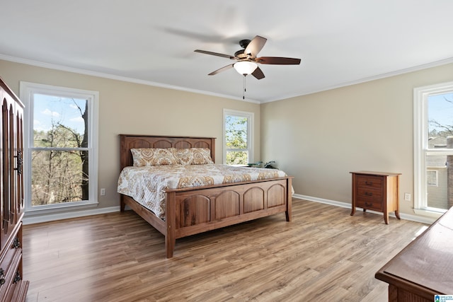 bedroom featuring crown molding, baseboards, and light wood finished floors